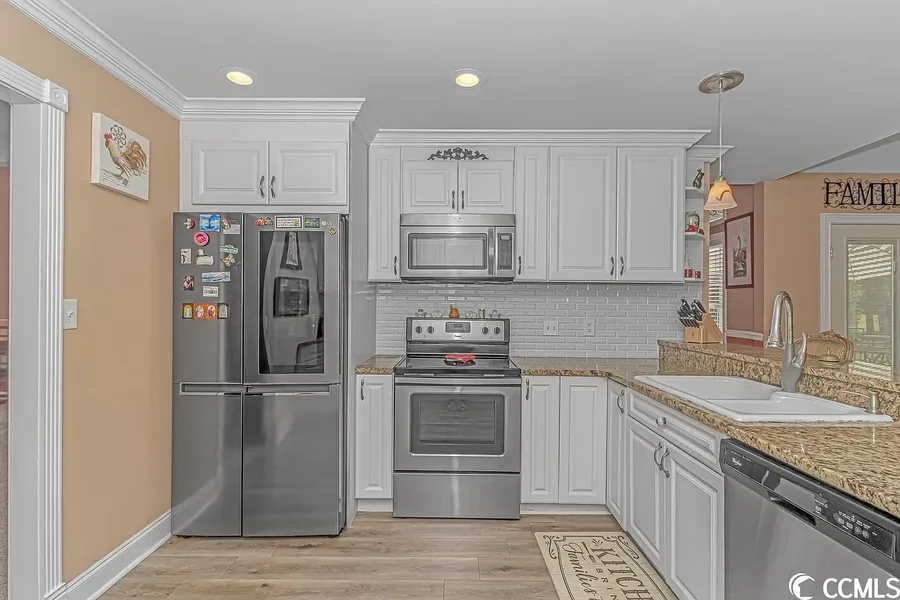 Remodeled kitchen with white cabinetry and granite countertops